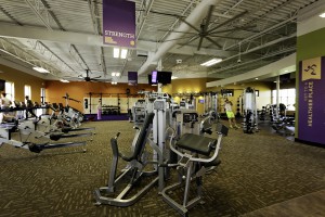 Inside an Anytime Fitness gym with cardio equipment on left and weights on the right