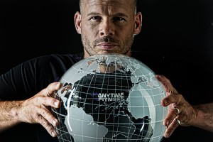 Dave Mortensen holding a glass frosted globe while wearing an anytime fitness t-shirt